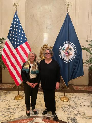 Françoise Moulin Civil et Hélène Aji devant le drapeau des États-Unis à la résidence de l'ambassadrice des États-Unis